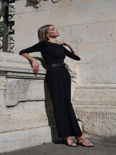 A woman wears a pair of black  high-waisted pants